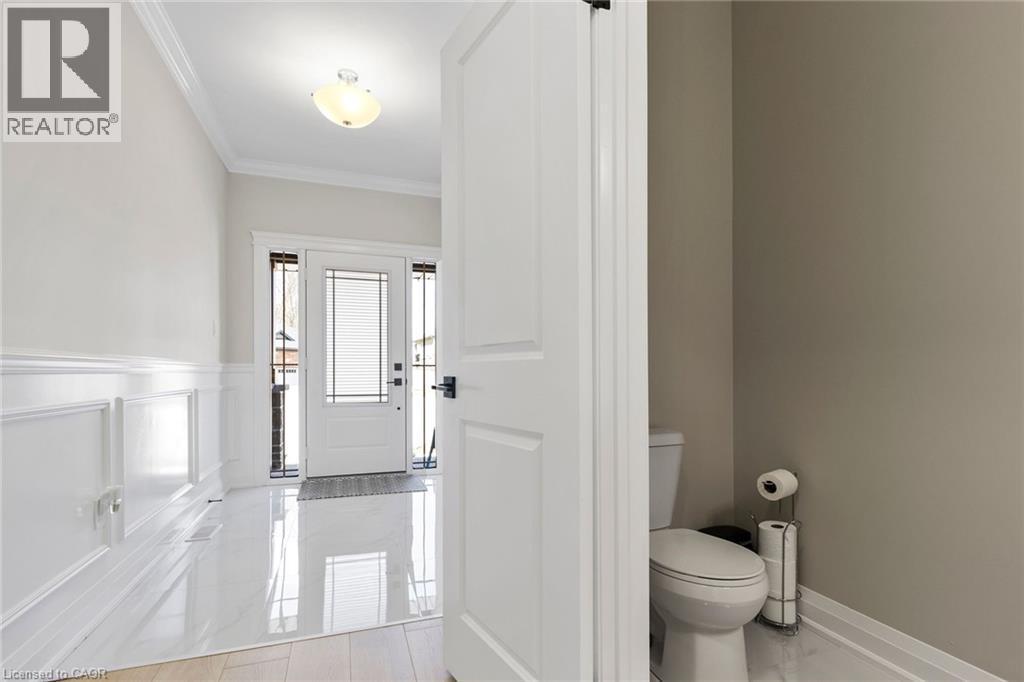 Bathroom with crown molding, wainscoting, and a decorative wall - 24 Tamarack Way, Simcoe, ON - Indoor Photo Showing Bathroom