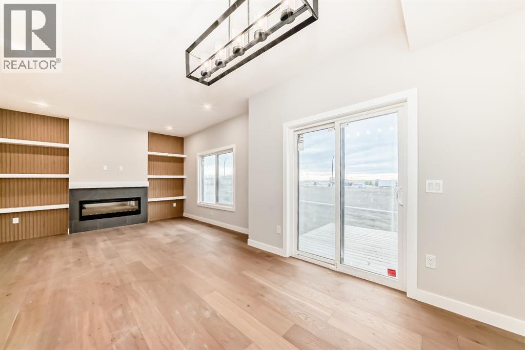 Patio doors leading to your back deck and yard - 508 Heritage Boulevard, Cochrane, AB - Indoor With Fireplace
