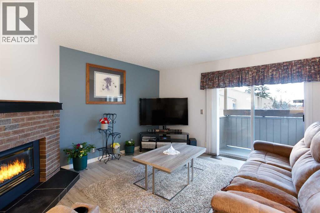 9, 225 Berwick Drive Nw, Calgary, AB - Indoor Photo Showing Living Room With Fireplace
