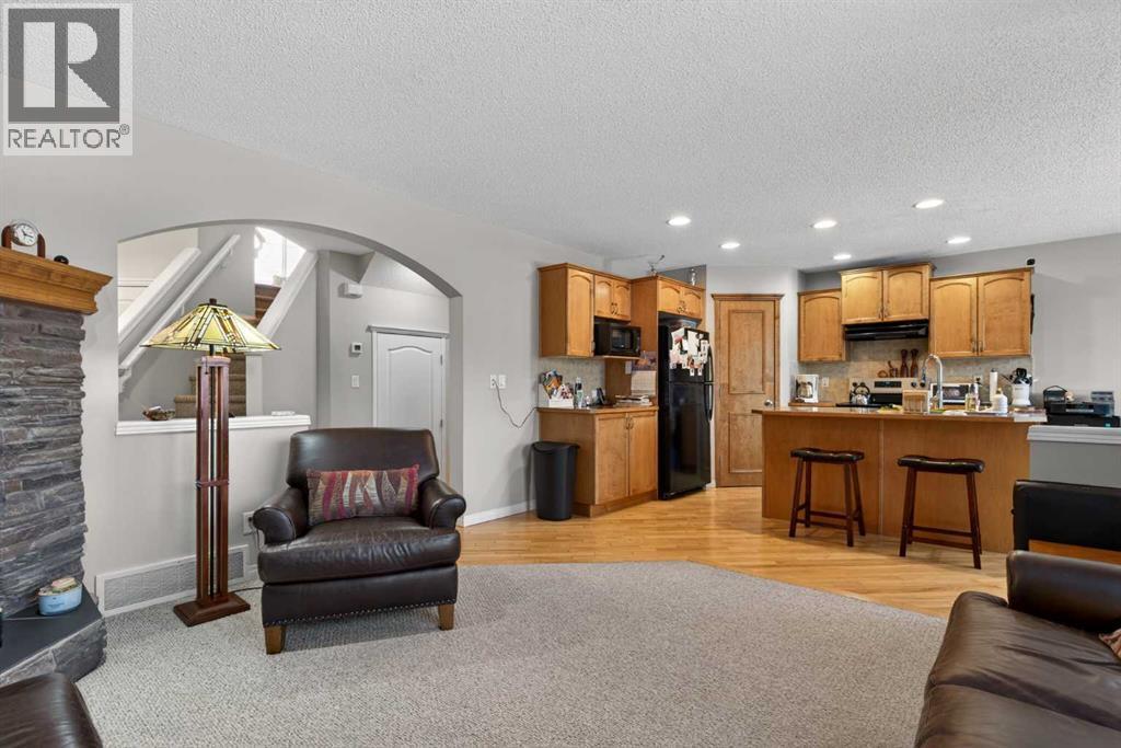 Living Room and Kitchen - 627 Auburn Bay Heights Se, Calgary, AB - Indoor With Fireplace