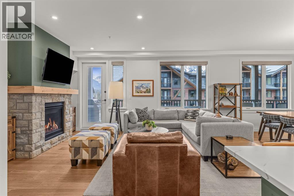 313, 1408 Spring Creek Gate, Canmore, AB - Indoor Photo Showing Living Room With Fireplace