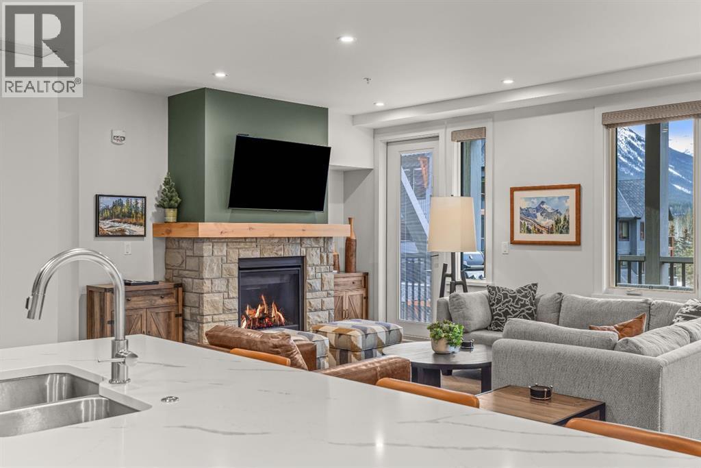 313, 1408 Spring Creek Gate, Canmore, AB - Indoor Photo Showing Living Room With Fireplace