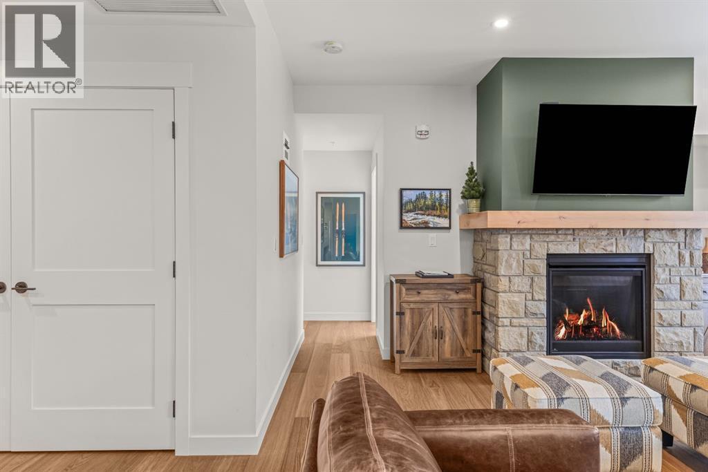 313, 1408 Spring Creek Gate, Canmore, AB - Indoor Photo Showing Other Room With Fireplace