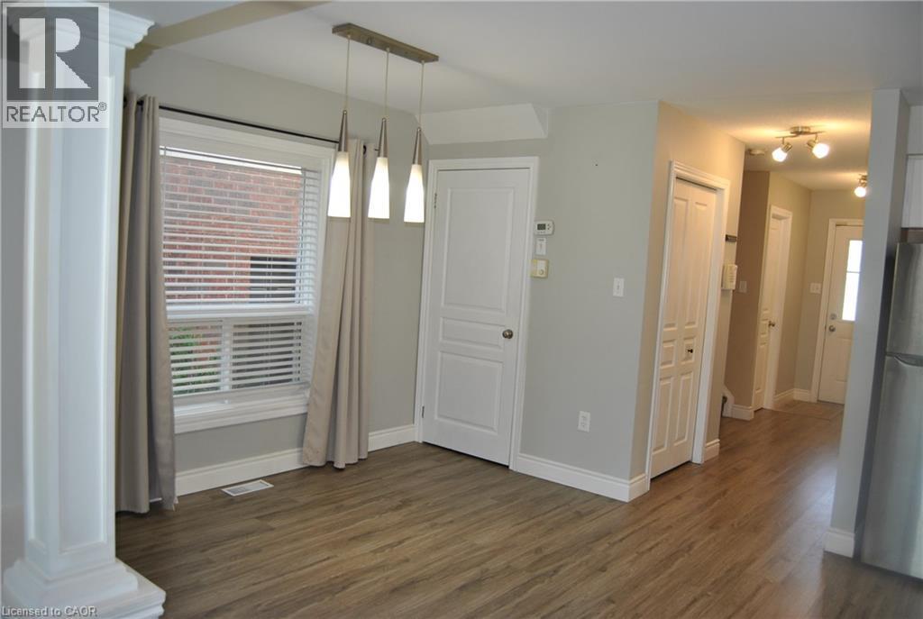 Unfurnished dining area featuring decorative columns and dark wood-style floors - 154 Harding Street, Kitchener, ON - Indoor Photo Showing Other Room