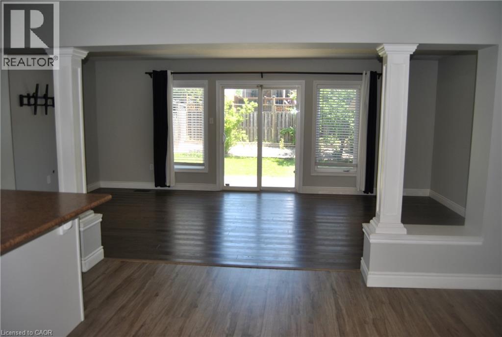 Unfurnished dining area featuring decorative columns and dark wood-style floors - 154 Harding Street, Kitchener, ON - Indoor