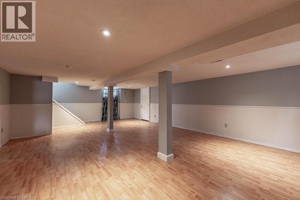 Finished below grade area featuring a textured ceiling, wainscoting, and light wood-style flooring - 854 West 5Th Street, Hamilton, ON - Indoor Photo Showing Other Room