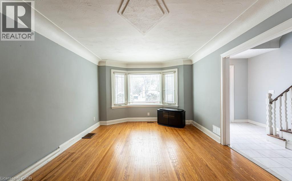 Unfurnished room with light wood-type flooring, baseboards, stairs, and visible vents - 854 West 5Th Street, Hamilton, ON - Indoor Photo Showing Other Room