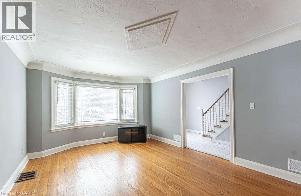 Spare room featuring stairs, visible vents, baseboards, and wood finished floors - 854 West 5Th Street, Hamilton, ON - Indoor Photo Showing Other Room