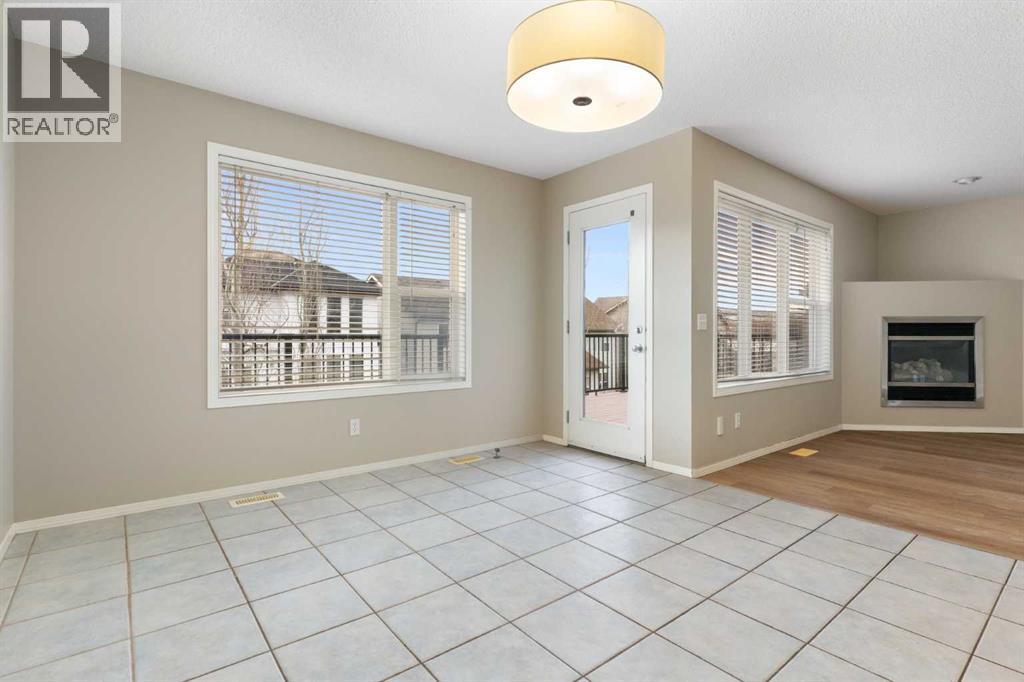 Dining room, balcony access - 129 Evansbrooke Way Nw, Calgary, AB - Indoor With Fireplace