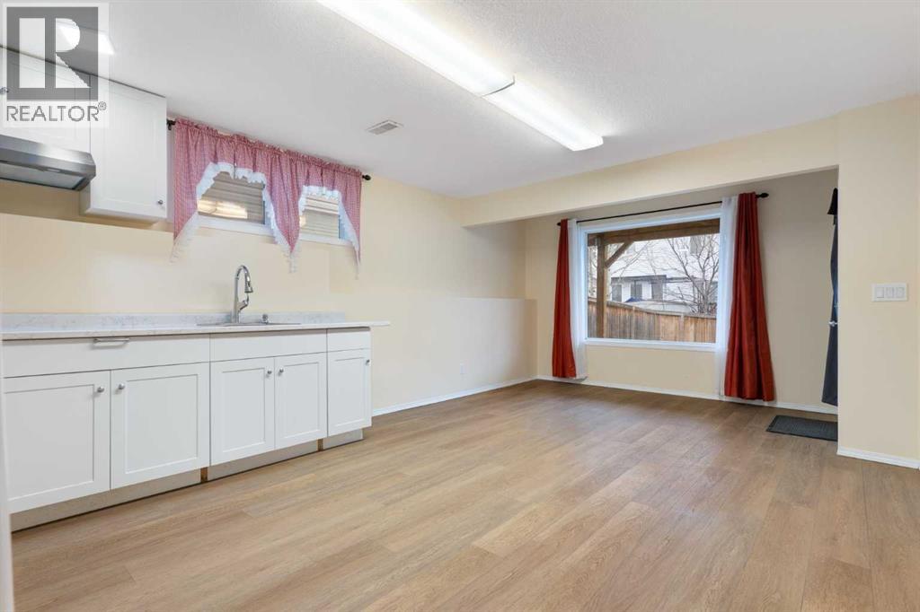 Lower-level living area, vinyl plank flooring - 129 Evansbrooke Way Nw, Calgary, AB - Indoor Photo Showing Other Room