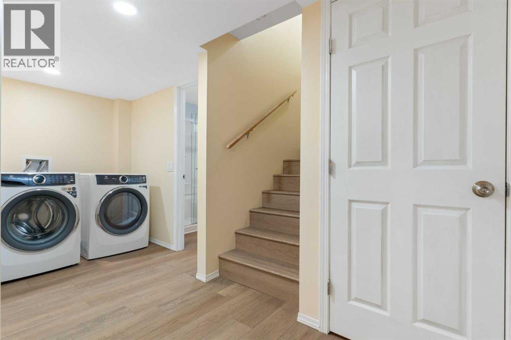 Lower-level laundry, front loading washer/dryer - 129 Evansbrooke Way Nw, Calgary, AB - Indoor Photo Showing Laundry Room