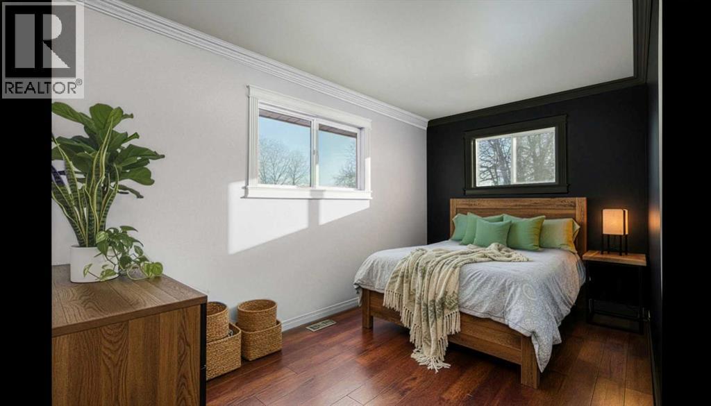 STAGED BEDROOM ON MAIN - 111 Macleod Trail E, Rural Foothills County, AB - Indoor Photo Showing Bedroom