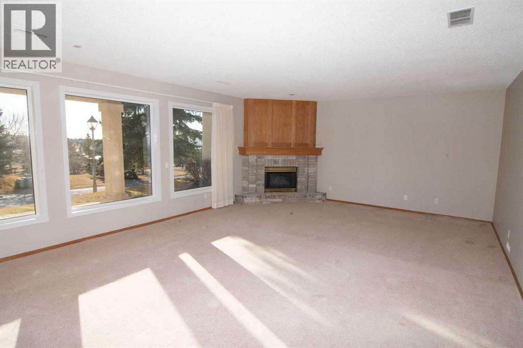 Family Room - 16 Eagleview Heights Nw, Cochrane, AB - Indoor Photo Showing Living Room With Fireplace