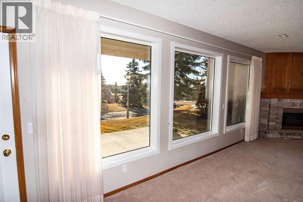 NEW Windows - 16 Eagleview Heights Nw, Cochrane, AB - Indoor With Fireplace