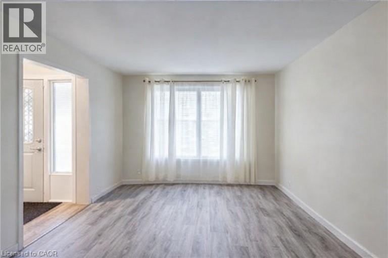 Unfurnished room featuring wood finished floors and baseboards - 310 Magnolia Drive, Hamilton, ON - Indoor Photo Showing Other Room