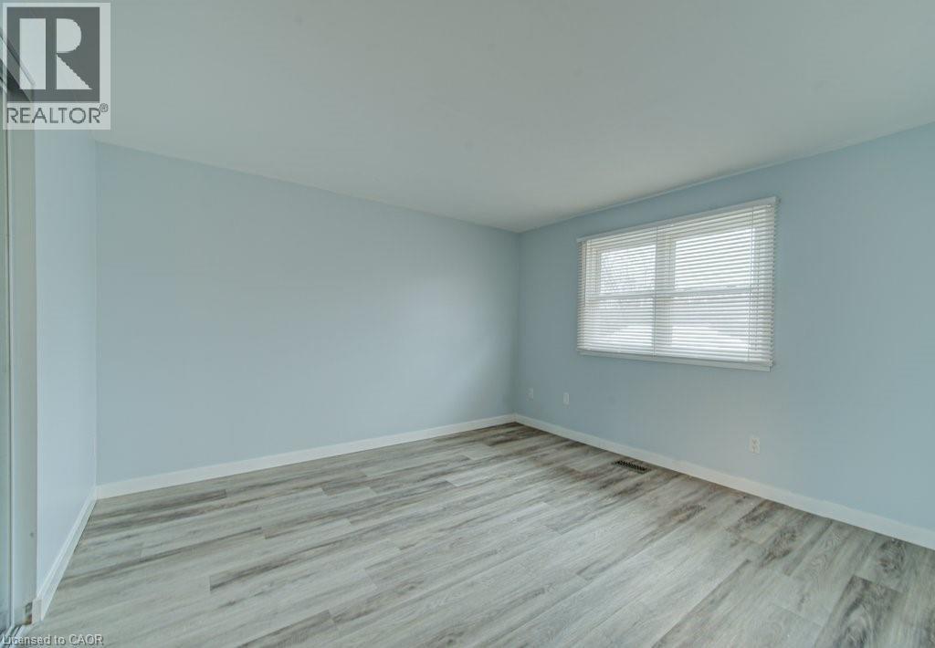 Unfurnished room with light wood-style floors and baseboards - 310 Magnolia Drive, Hamilton, ON