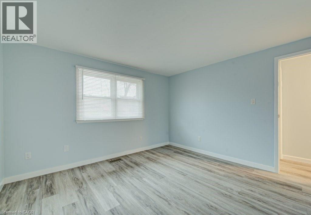Unfurnished room with light wood-style flooring and baseboards - 310 Magnolia Drive, Hamilton, ON