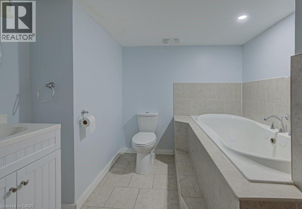 Full bathroom featuring vanity, a garden tub, light tile patterned floors, and recessed lighting - 310 Magnolia Drive, Hamilton, ON