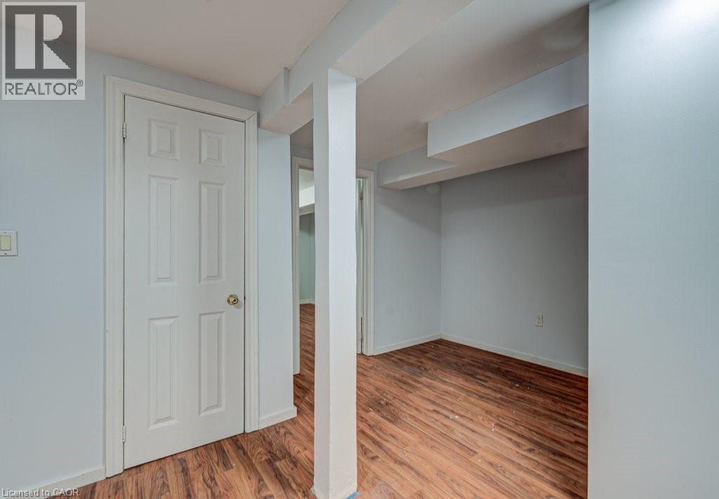 Finished below grade area with light wood finished floors and baseboards - 310 Magnolia Drive, Hamilton, ON