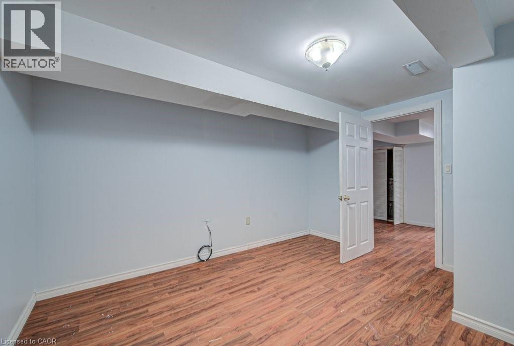 Finished below grade area with baseboards and light wood-style flooring - 310 Magnolia Drive, Hamilton, ON