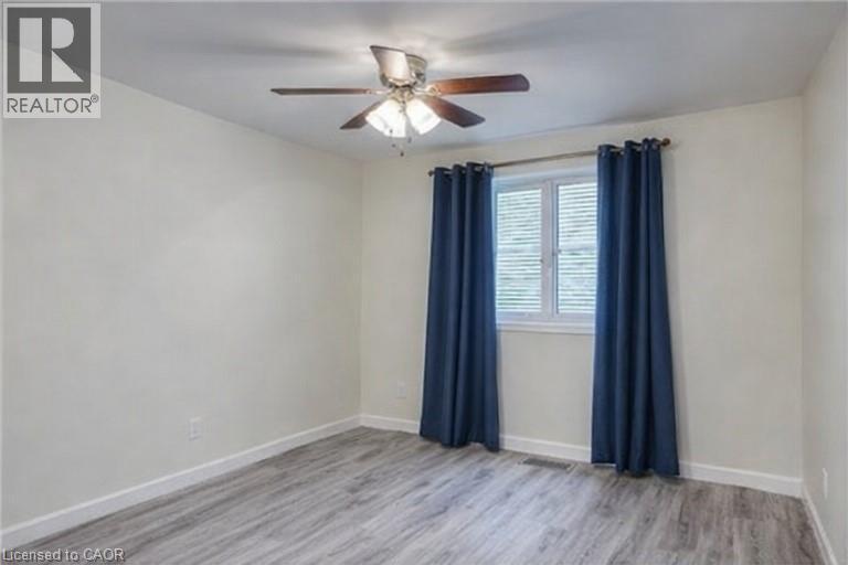 Empty room with light wood finished floors and ceiling fan - 310 Magnolia Drive, Hamilton, ON - Indoor Photo Showing Other Room