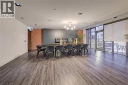 Dining space featuring dark wood finished floors, floor to ceiling windows, and a chandelier -