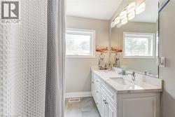 Full bath with double vanity and a shower with shower curtain -