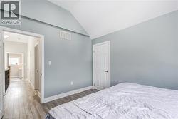 Bedroom with lofted ceiling and wood finished floors -