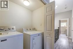 Laundry area with washing machine and dryer and wood finished floors -