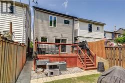 Rear view of property with a wooden deck and a fenced backyard -