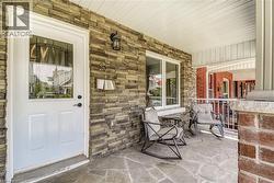 Property entrance featuring a porch and stone siding -