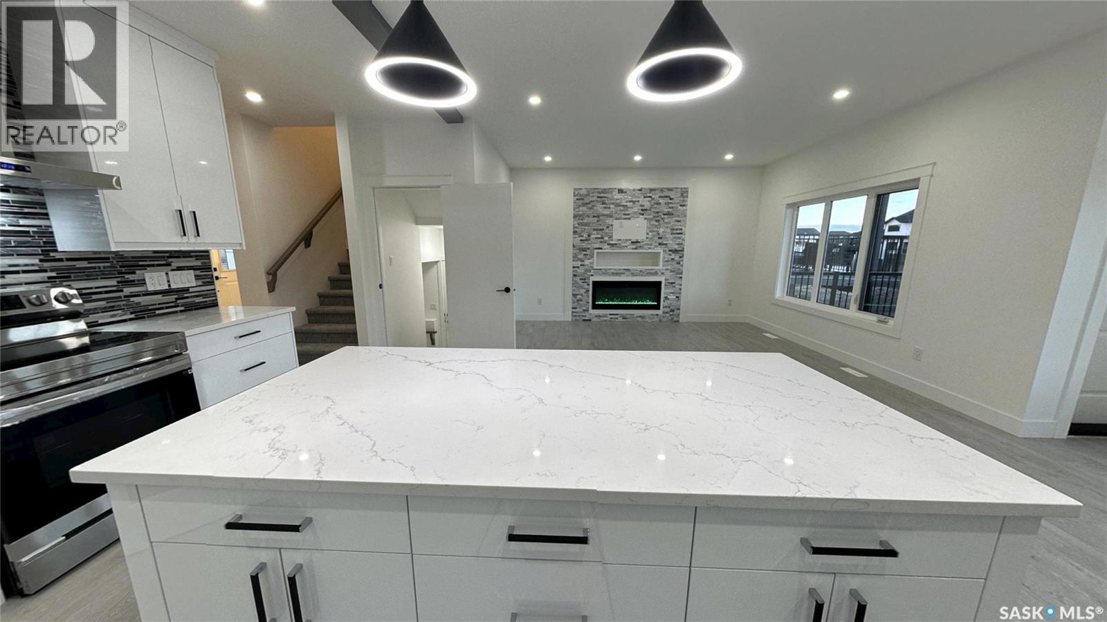 147 Woolf Bend, Saskatoon, SK - Indoor Photo Showing Kitchen With Fireplace