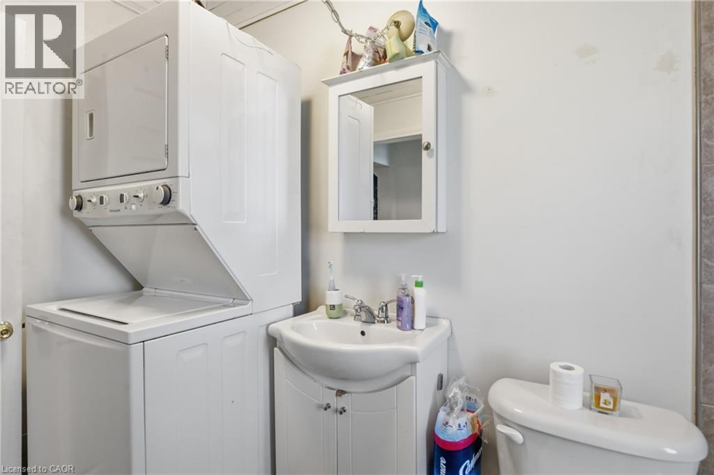 Half bath featuring vanity and stacked washing machine and dryer - 260 Prospect Street S, Hamilton, ON - Indoor