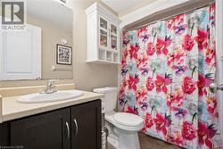Full bath featuring a shower with curtain, vanity, dark tile patterned floors, and a textured ceiling -