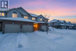 View of front of property with board and batten siding, brick siding, and a garage -