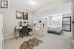 Bedroom with light colored carpet and an office area -