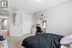 Bedroom featuring light colored carpet and a closet -