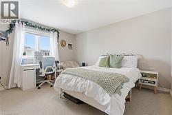 Bedroom with a desk and light carpet -