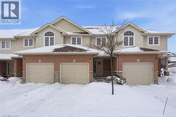 View of front facade featuring board and batten siding, an attached garage, and brick siding -