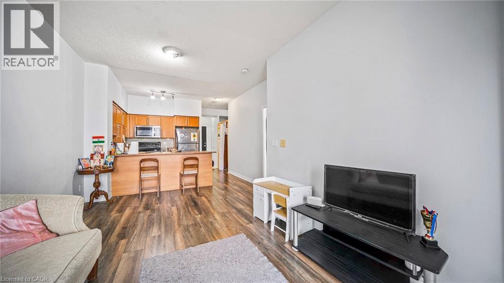 Living room featuring dark wood-type flooring and a textured ceiling - 388 Prince Of Wales Drive Unit# 1609, Mississauga, ON - Indoor