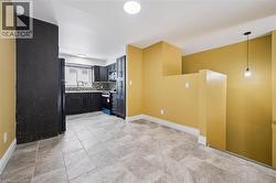 Kitchen featuring dark cabinets, range, hanging light fixtures, light countertops, and tasteful backsplash -