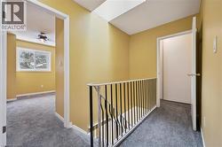 Corridor with carpet and an upstairs landing -