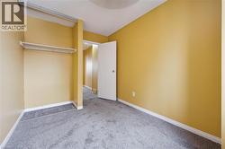 Unfurnished bedroom with carpet flooring and baseboards -
