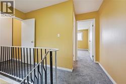 Hallway with an upstairs landing and carpet floors -