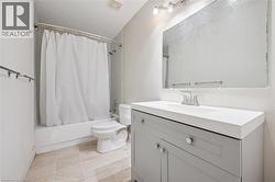 Full bathroom with vanity, shower / tub combo, and light tile patterned floors -