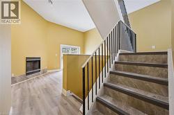 Staircase with wood finished floors and a fireplace -