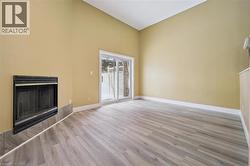 Unfurnished living room featuring a fireplace, light wood-type flooring, and vaulted ceiling -