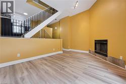 Unfurnished living room with light wood finished floors, a fireplace, and a high ceiling -