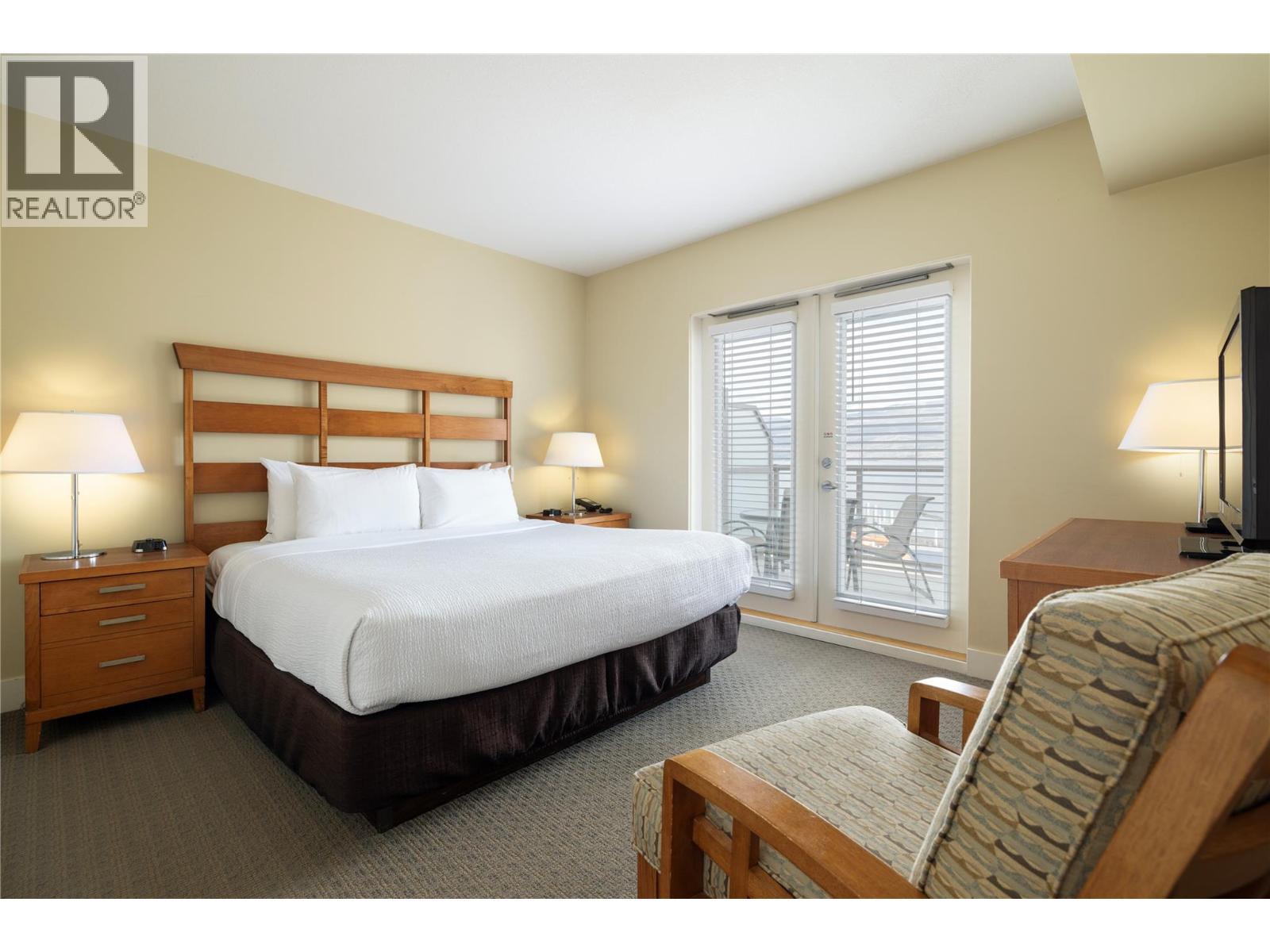 Primary Bedroom w/ french doors to balcony. - 4205 Gellatly Road Unit# 416, West Kelowna, BC - Indoor Photo Showing Bedroom