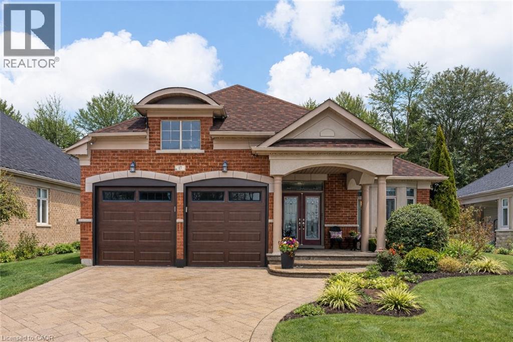 View of front of home featuring brick siding, covered porch, decorative driveway, a front yard, and a shingled roof - 17 Mcnutt Street, Brampton, ON - Outdoor